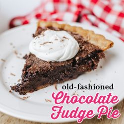 chocolate fudge pie slice on a white plate topped with whipped cream