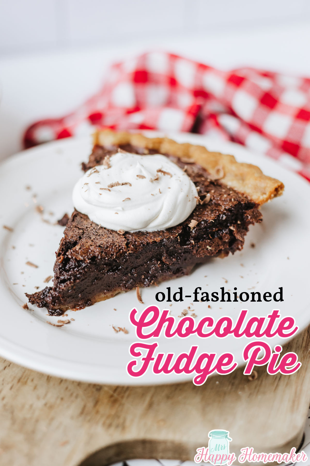 chocolate fudge pie slice on a white plate topped with whipped cream