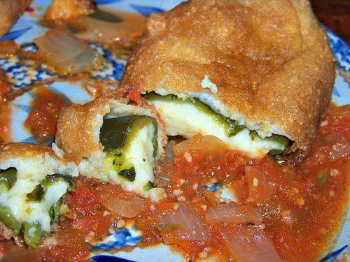 Chiles Rellenos with sauce on a blue plate