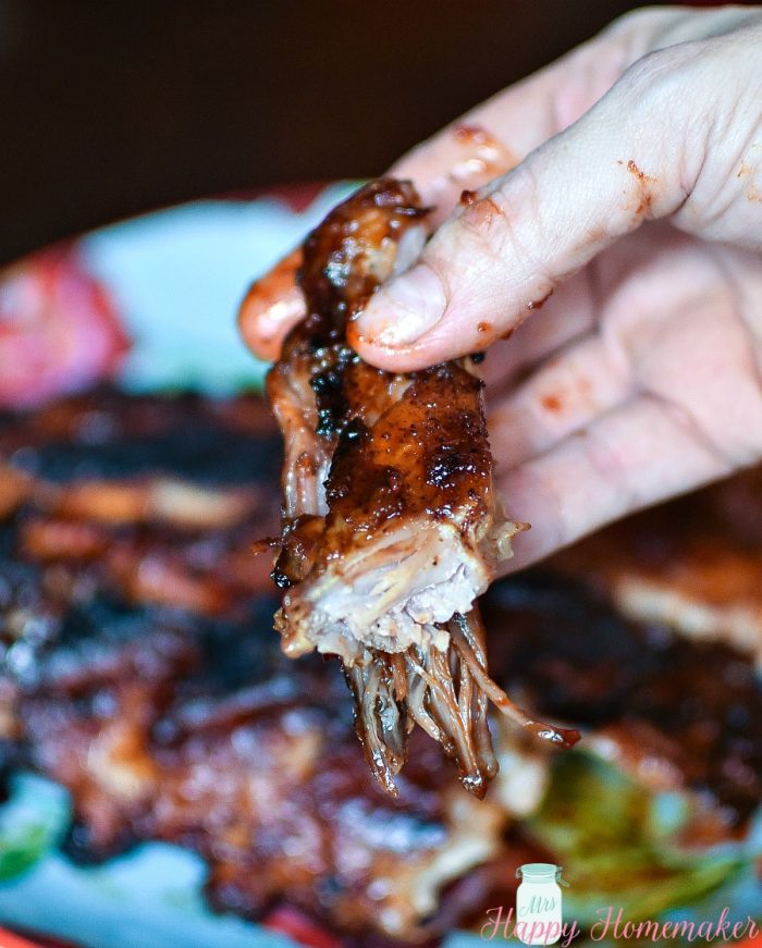 bbq ribs close up being held with a hand 