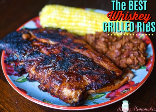 The BEST Whiskey Glazed Ribs on a plate with baked beans and corn on the cob | MrsHappyHomemaker.com