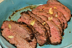 Eye of round roast sliced thin with pieces of garlic