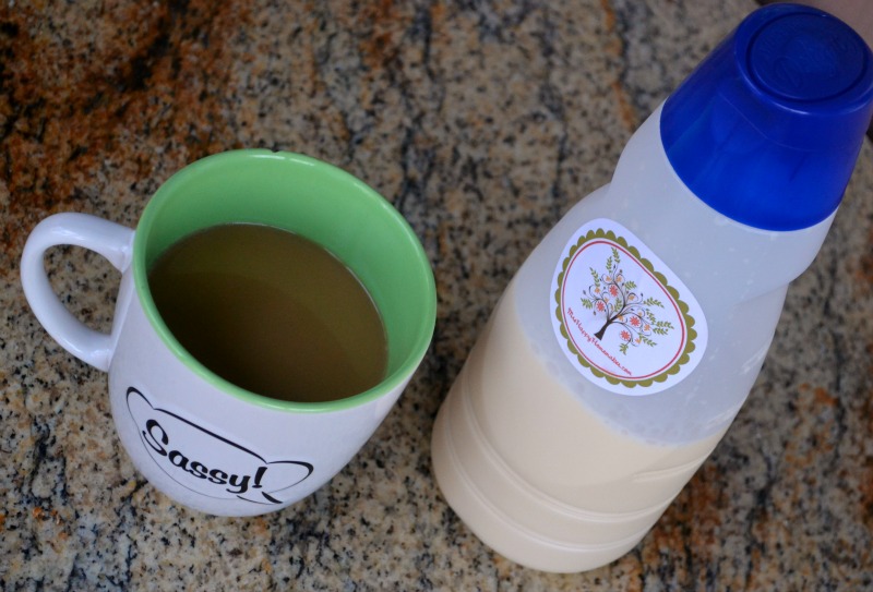 A cup of coffee with a bottle of homemade creamer