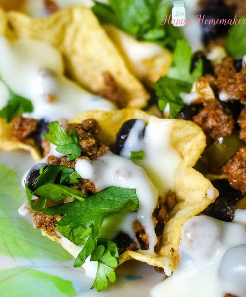 closeup picture of loaded super nachos with ground beef and cheese sauce