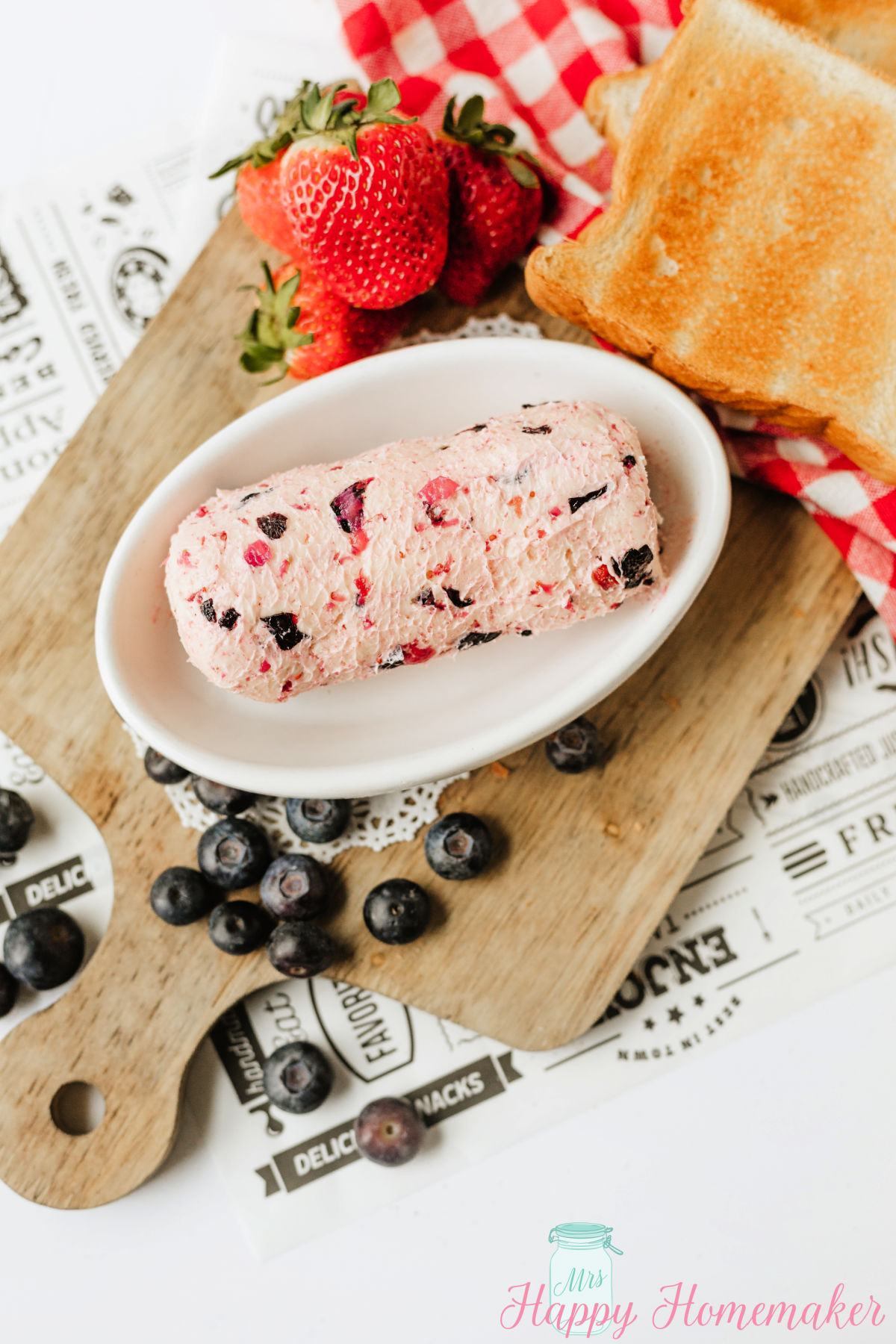 Berry Butter in a white oval dish surrounded by fresh berries
