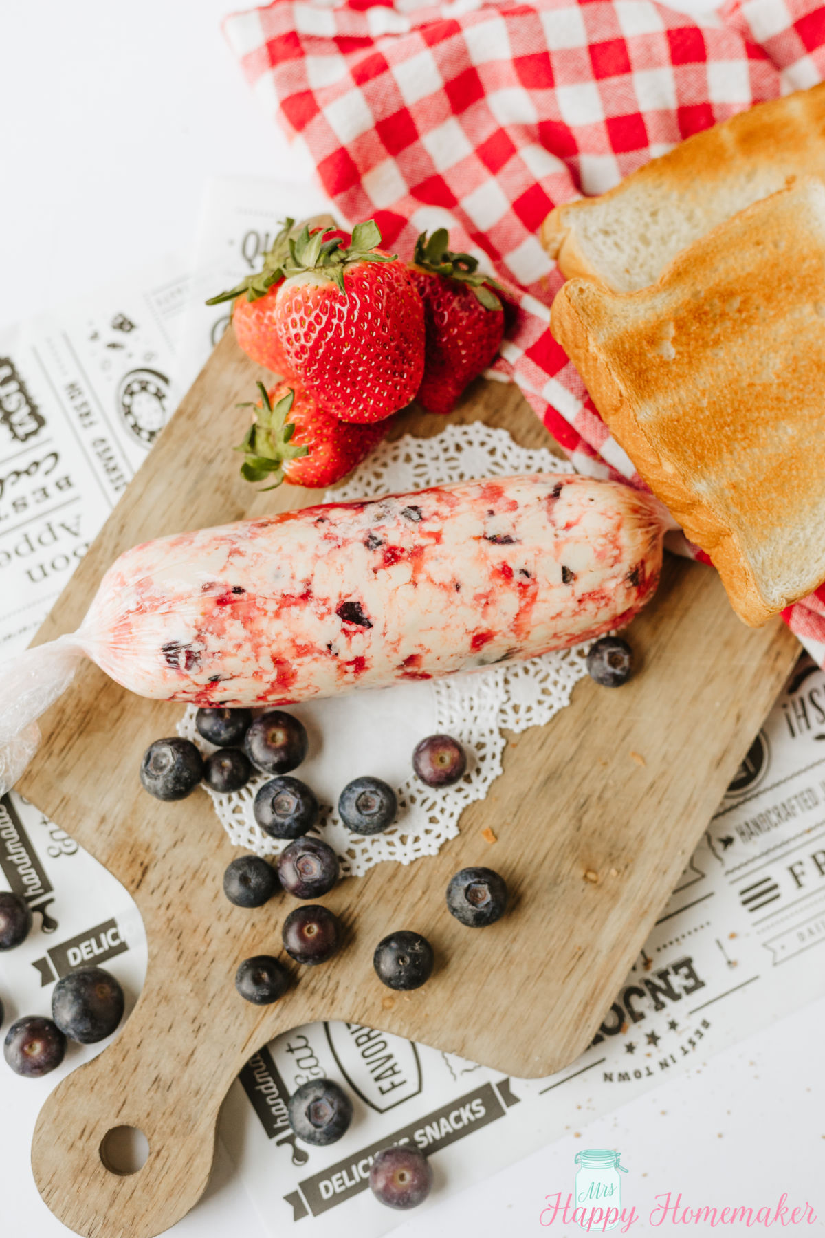 berry butter on a cutting board surrounded by fresh berries