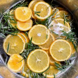 Turkey brine in a big pot with sliced oranges and rosemary
