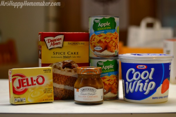 The ingredients for Easy Caramel Apple Trifle lined up on the countertop - instant pudding, cake mix, pie filling, caramel, and cool whip