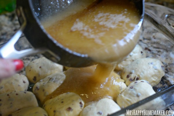 Caramel being poured over Cinnamon Roll Apple Dumplings - as in these delicious apple dumplings are encased with cinnamon rolls!|  MrsHappyHomemaker.com 