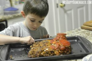 little boy helping to make a meatloaf shaped like a foot