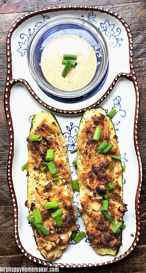 Crab Stuffed Zucchini Boats garnished with green onions with ranch 