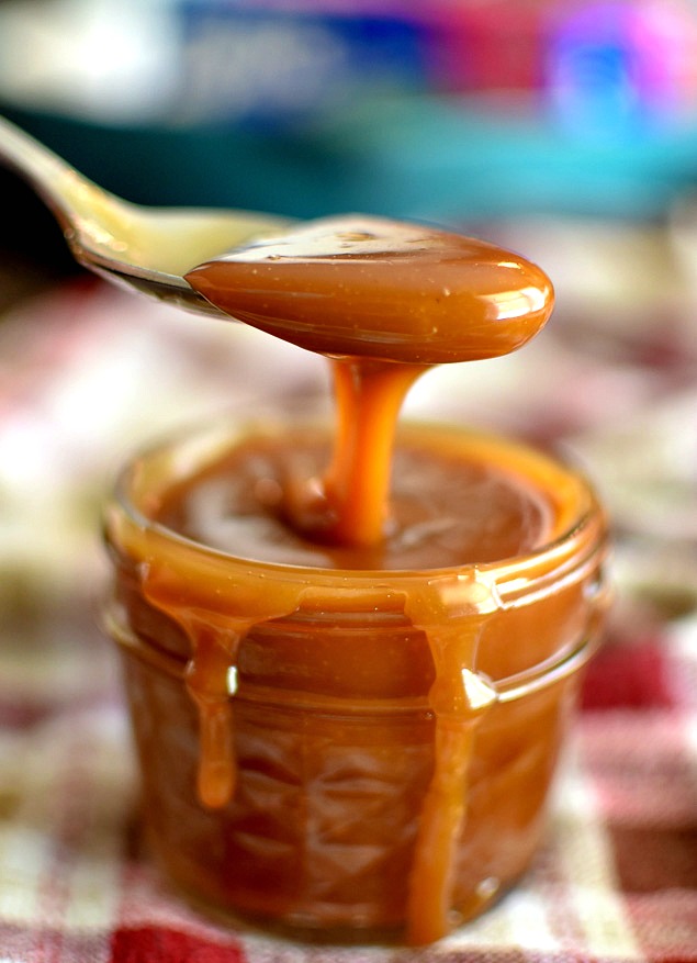 Salted Caramel Sauce being spooned out of a small jar 