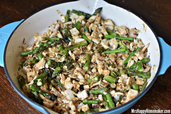 chicken and asparagus cooking in a skillet 
