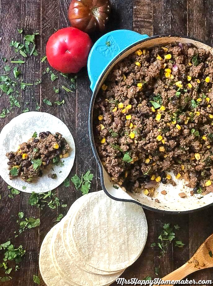 Taco filling in a skillet and a flour tortilla 