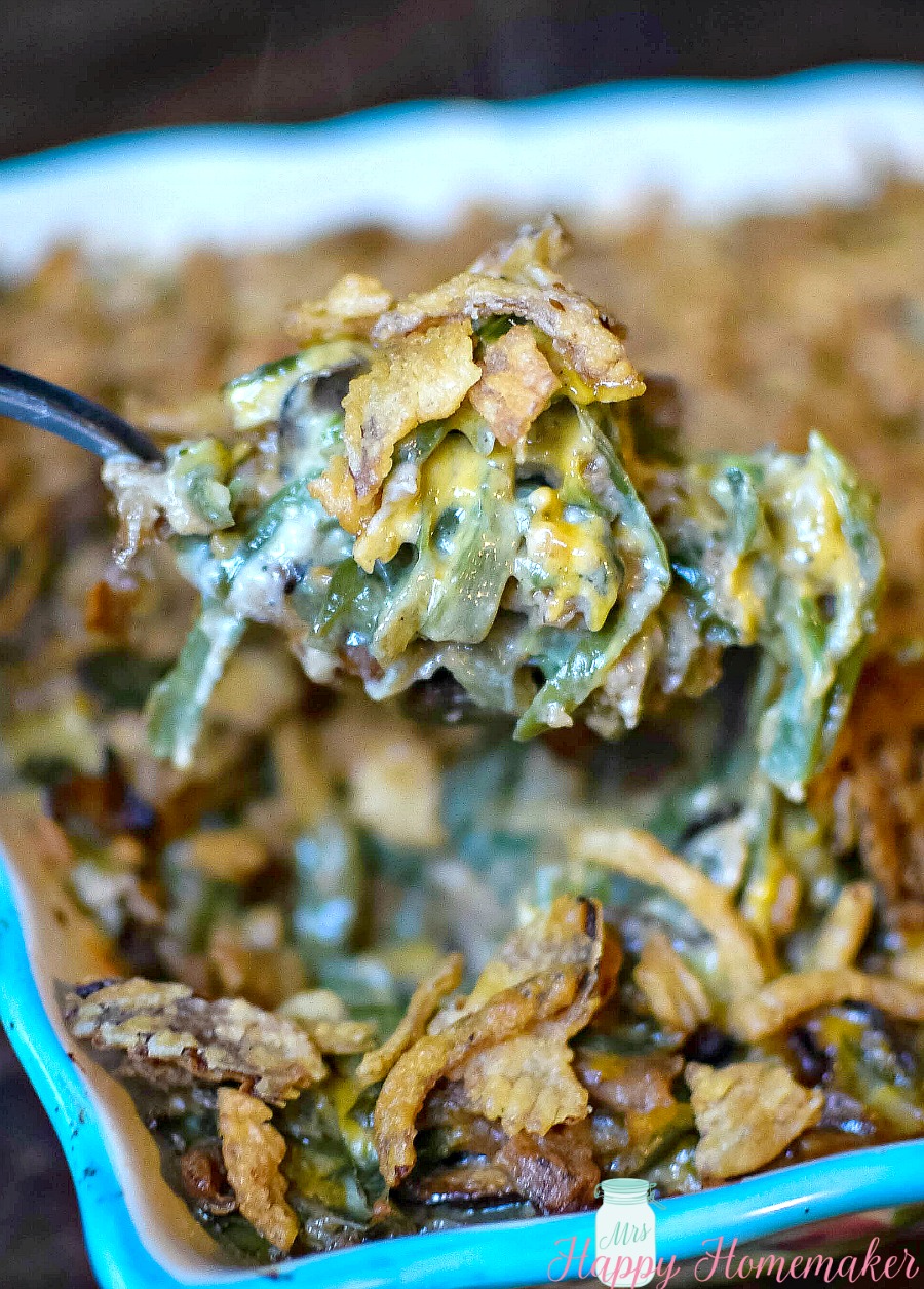 The BEST Homemade Green Bean Casserole with no canned soup, scooping it out of the casserole dish with a spoon | MrsHappyHomemaker.com 