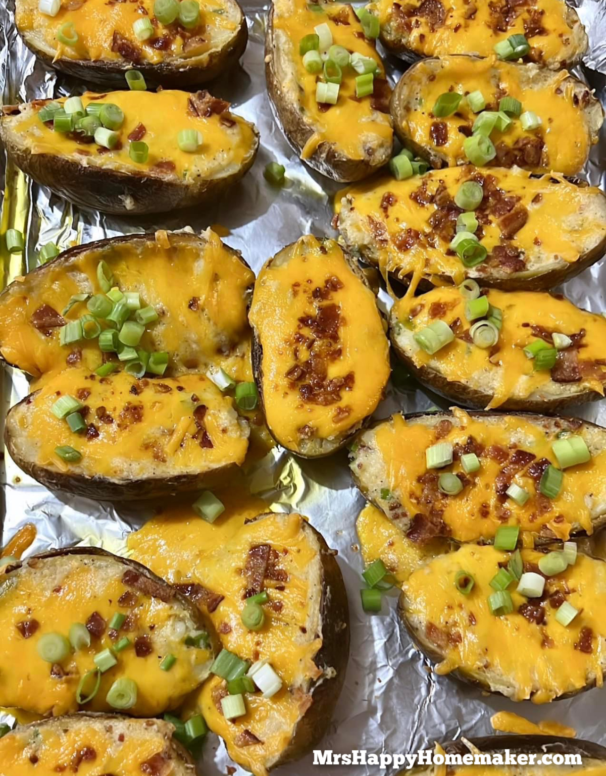 About 15 Twice Baked Stuffed Potatoes on a tinfoil lined baking sheet