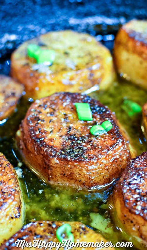 Melting Potatoes - round potatoes cooked in butter in a cast iron skillet, garnished with green onions | MrsHappyHomemaker.com