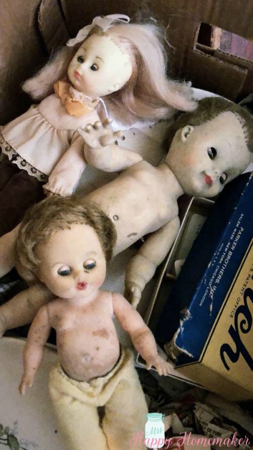 a box full of 3 old creepy dolls