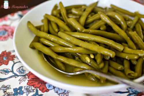 Cooked to Death Green Beans in a serving bowl with a big spoon