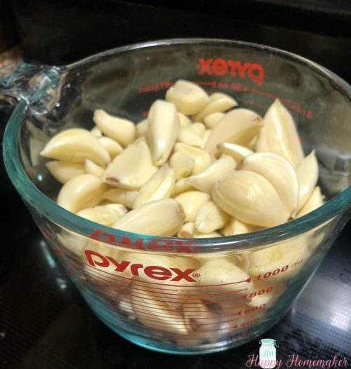 peeled garlic cloves in a measuring cup