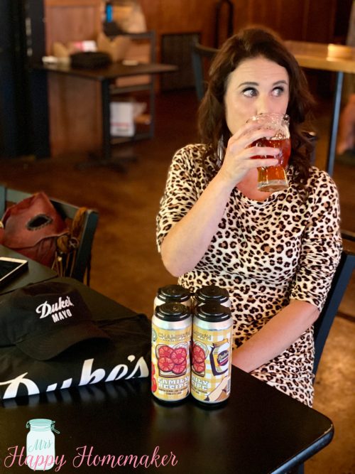 Mrs Happy Homemaker holding Dukes Mayo and Champion Brewery collaboration beer, Family Recipe