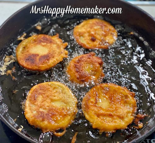 Beer battered fried green tomatoes frying in a skillet