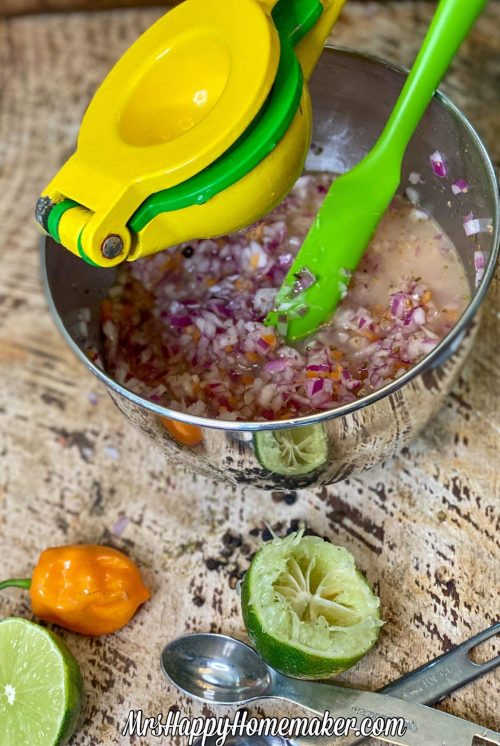 Squeezing a lime into the habanero red onion salsa