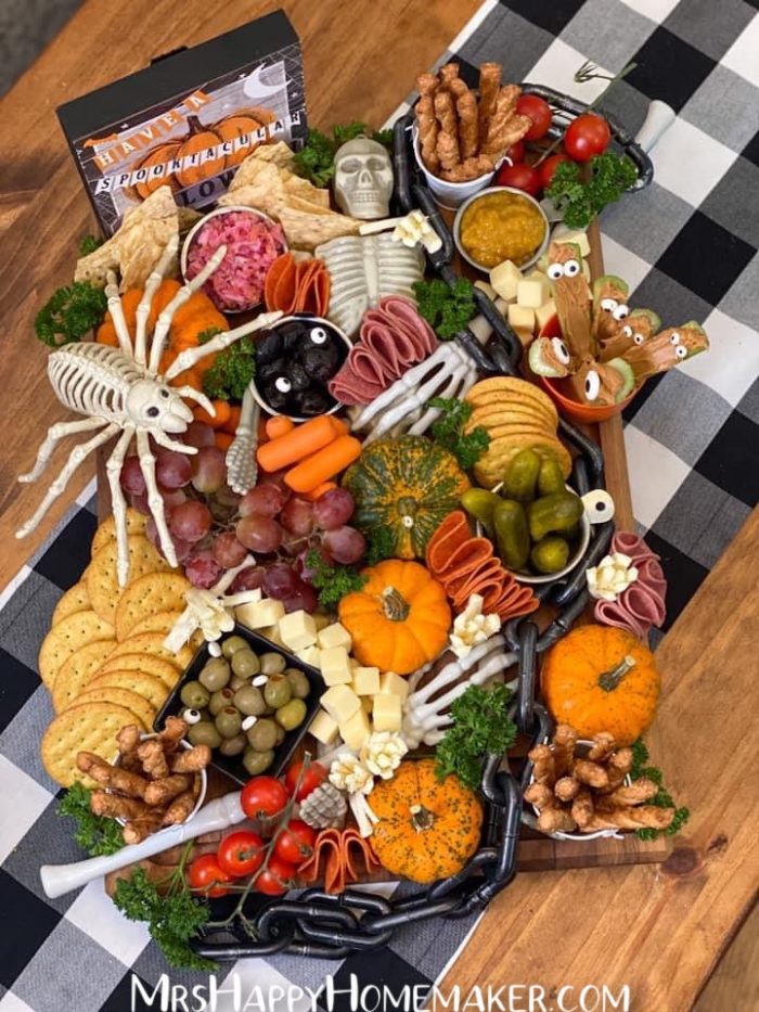 Halloween charcuterie board with a skeleton in the middle lined with meats and cheeses 