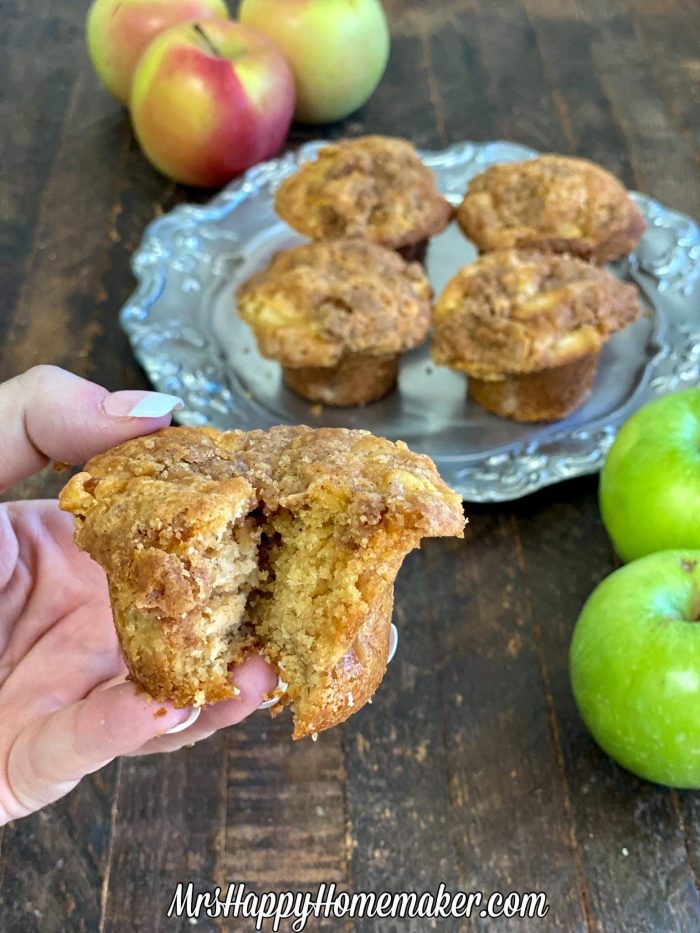 Apple pie muffins on a silver plate surrounded by apples