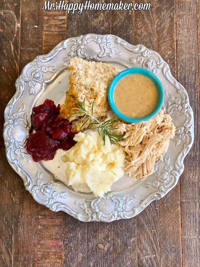 Thanksgiving leftovers on a silver plate - cranberry sauce, mashed potatoes, dressing, gravy, and turkey