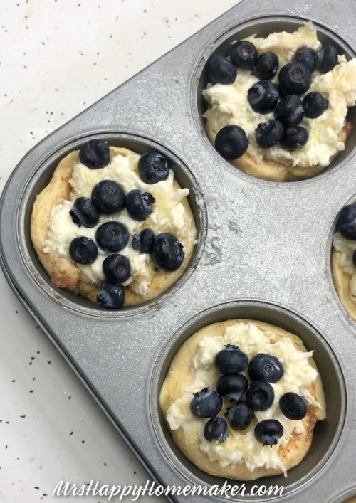 Pineapple blueberry muffin cups in a muffin tin before baking