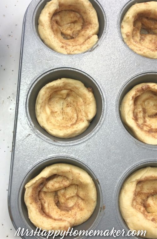 Refrigerated cinnamon roll dough lining muffin tin cups