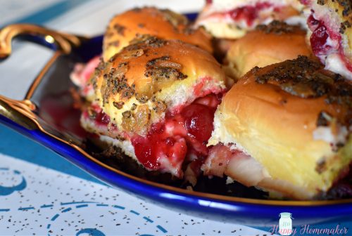 turkey cranberry sauce and brie cheese baked sliders on a blue platter