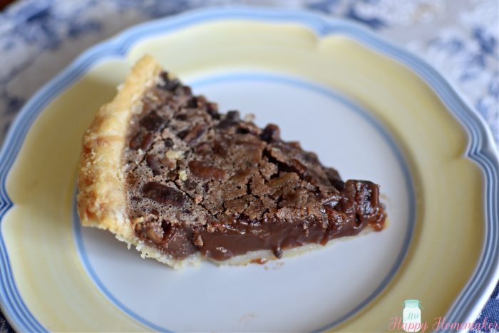 chocolate pecan pie slice on a yellow rimmed plate