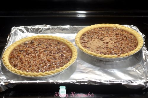 two chocolate pecan pies, unbaked, on a tin foil lined baking sheet