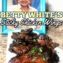 Betty White’s chicken wings with a framed picture of betty white behind them