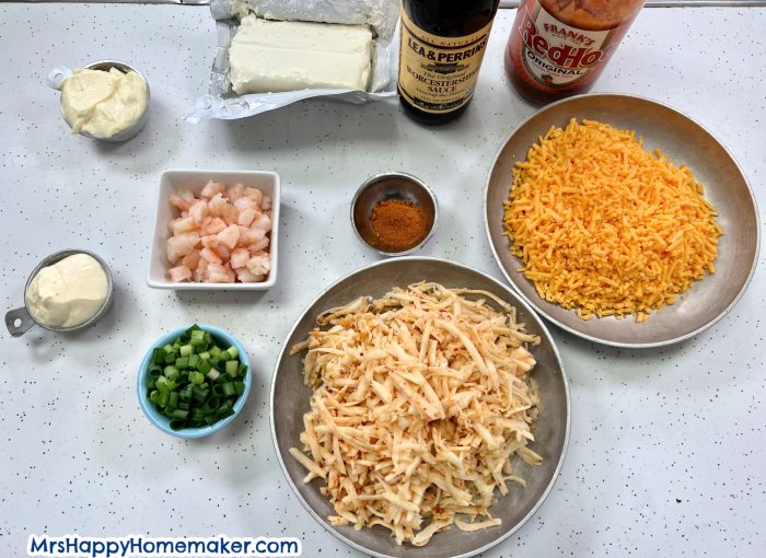 All of the ingredients for my baked shrimp dip in separate containers on a white countertop 