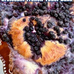 Blueberries and cream croissant French toast casserole in a brown rimmed casserole dish