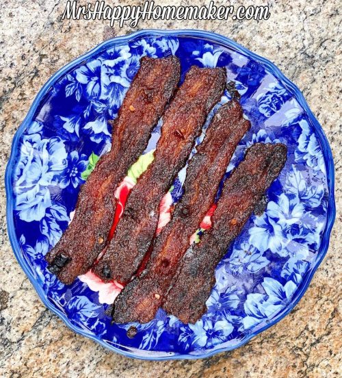 4 pieces of candied bacon on a blue plate