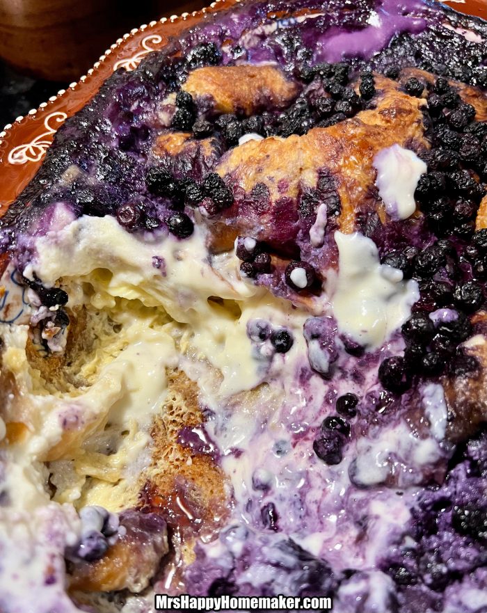 Blueberries and cream croissant French toast bake in a brown rimmed baking dish