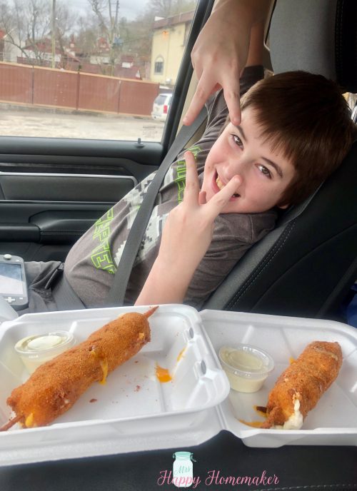 2 cheese kabobs next to my little boy, who is giving the peace sign