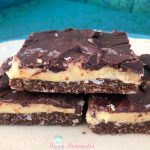 3 Nanaimo bars piled up on a white plate