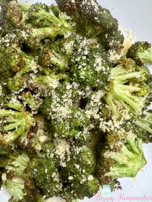 Air fryer broccoli in a white dish With cheese sprinkled on top