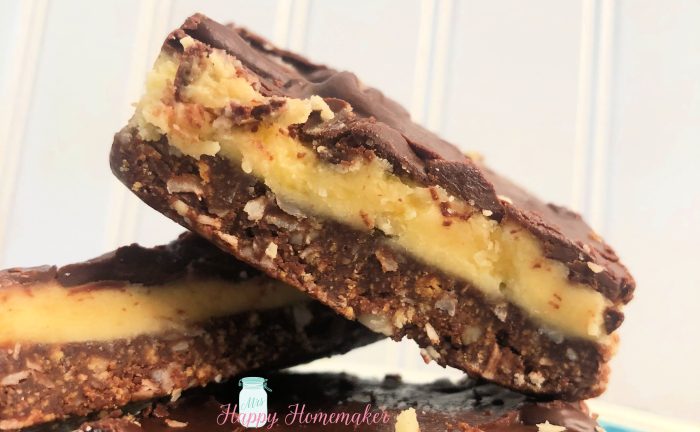 3 Nanaimo bars piled up on a white plate