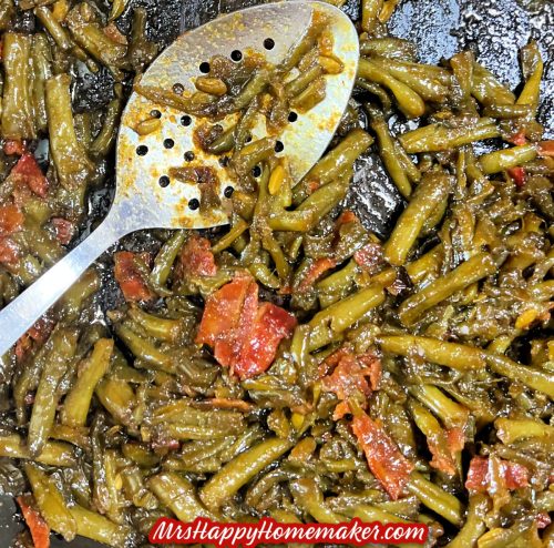 Crack green beans with bacon in a skillet With a large silver spoon