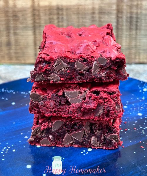 Three Red velvet cookie bars stacked up on a blue plate
