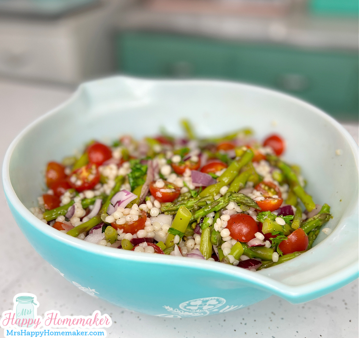 pearl couscous salad with asparagus & cherry tomatoes in a vintage blue Pyrex bowl