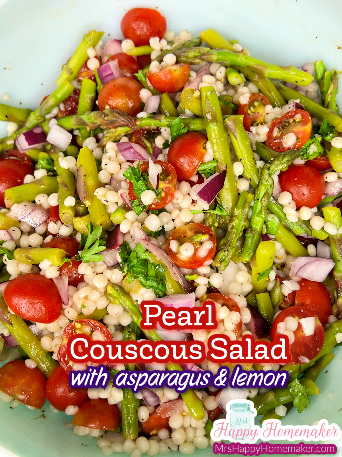 Closeup of pearl couscous salad with asparagus & cherry tomatoes in a bowl