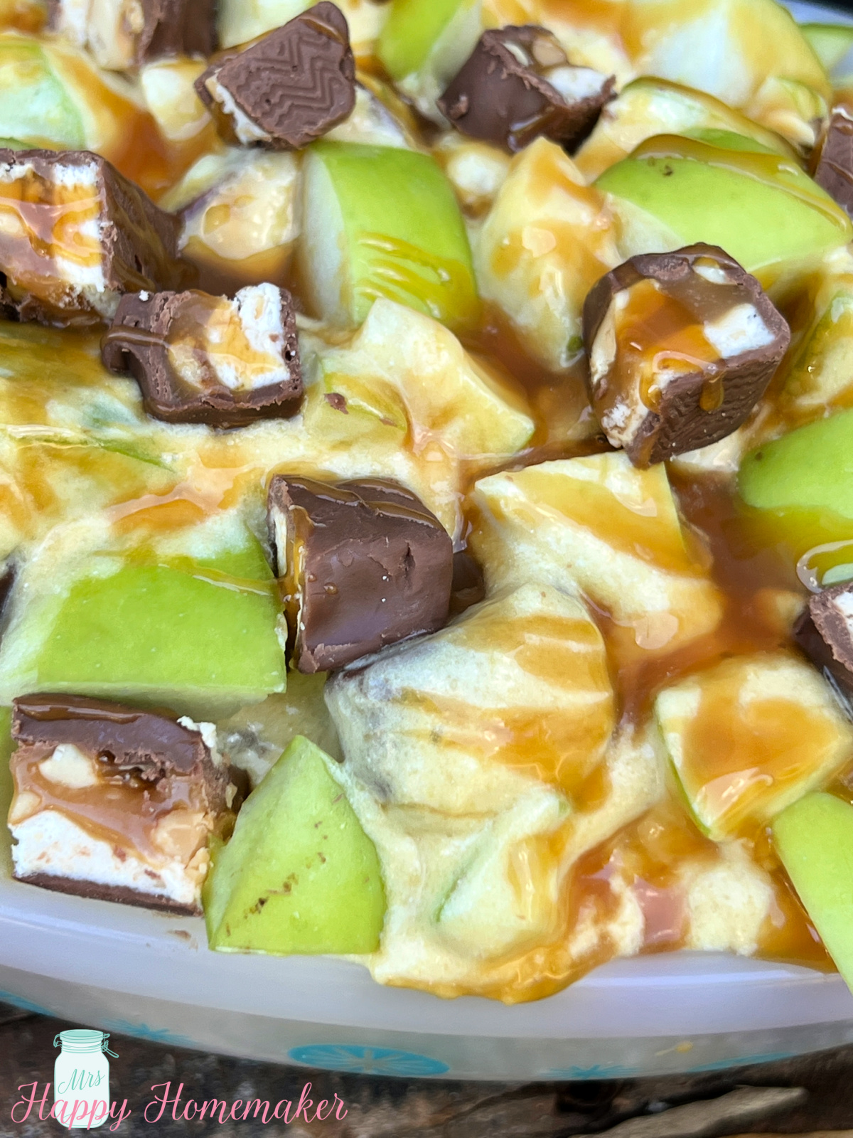 Closeup of snickers apple salad in a white casserole dish