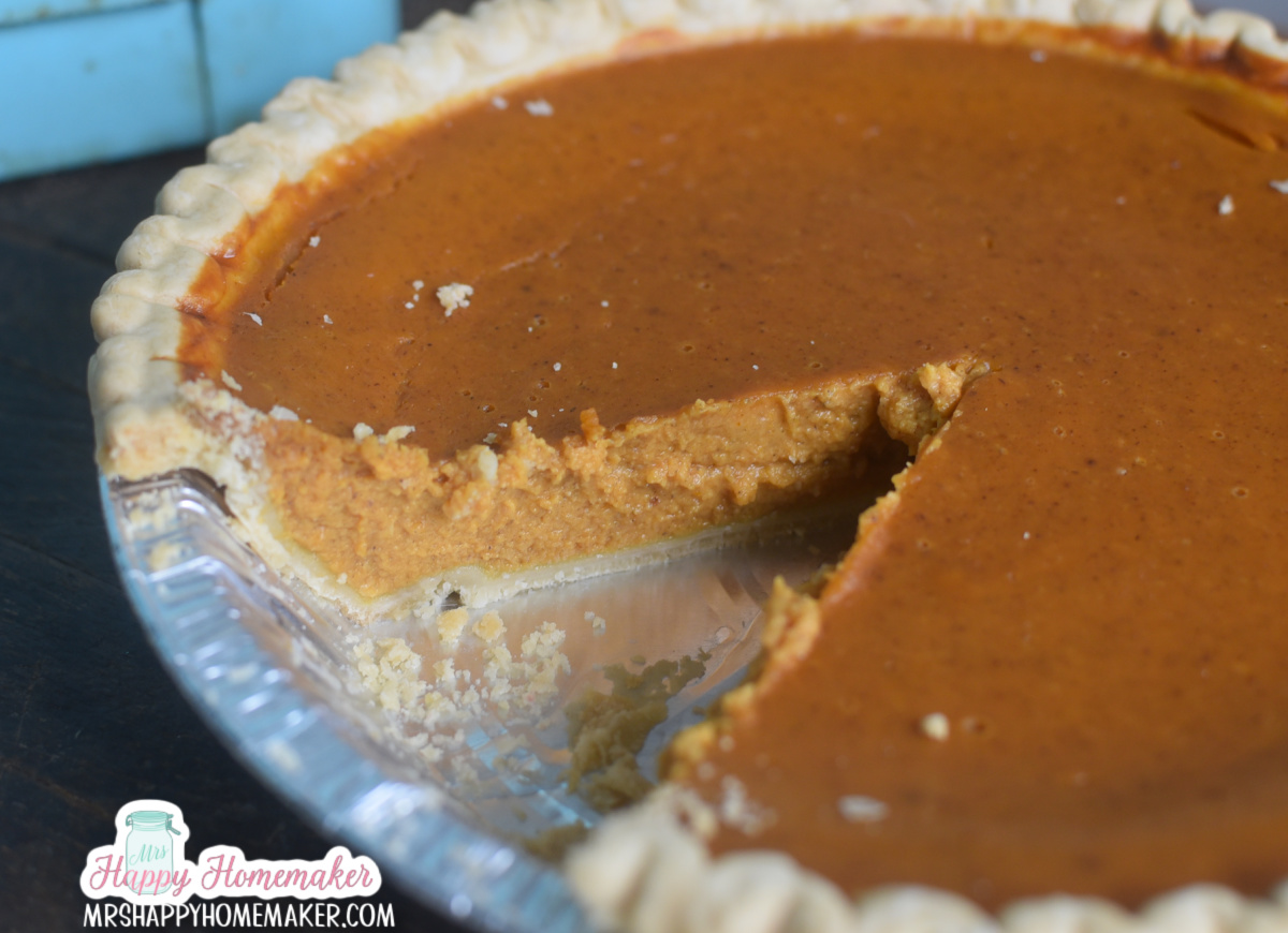 A pumpkin pie with a slice missing